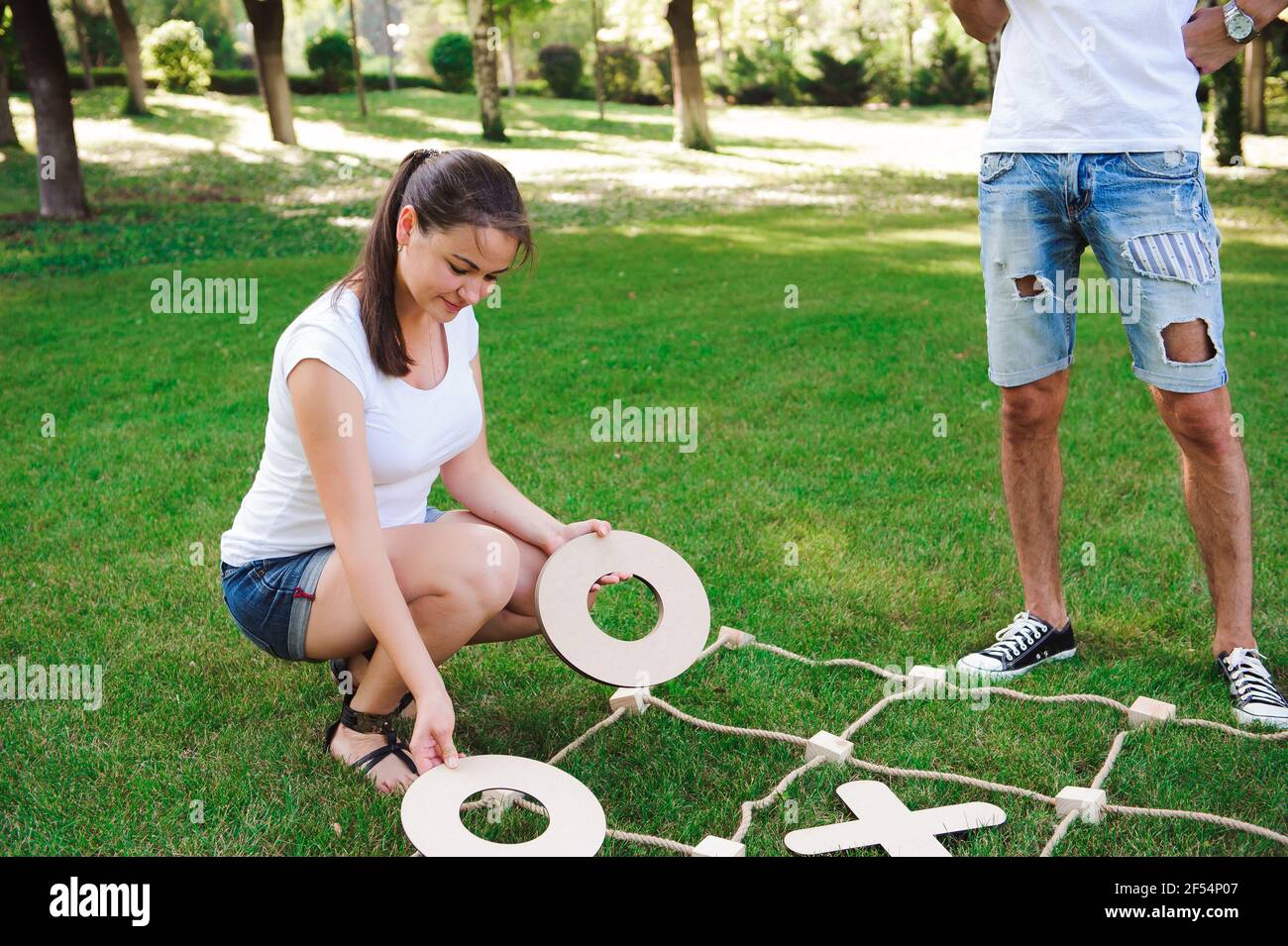 Big Tic Tac Toe Spiel. Guy und Mädchen spielen im Freien Stockfoto