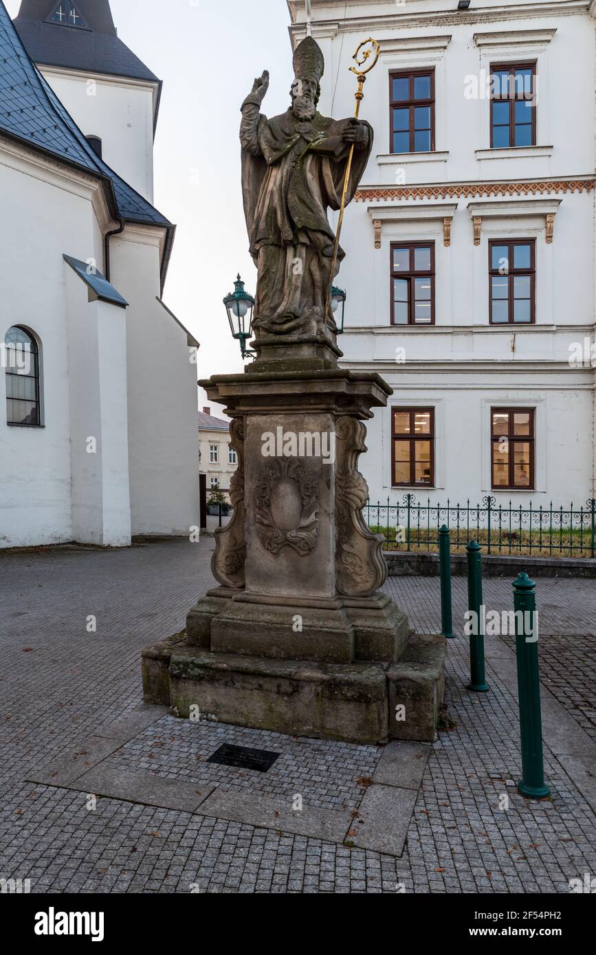 Statue des Heiligen Patrick auf Masarykovo namesti Platz mit Kostel Povyseni sv. Krize churh auf dem Hintergrund in Karvina Stadt in Tschechien Stockfoto