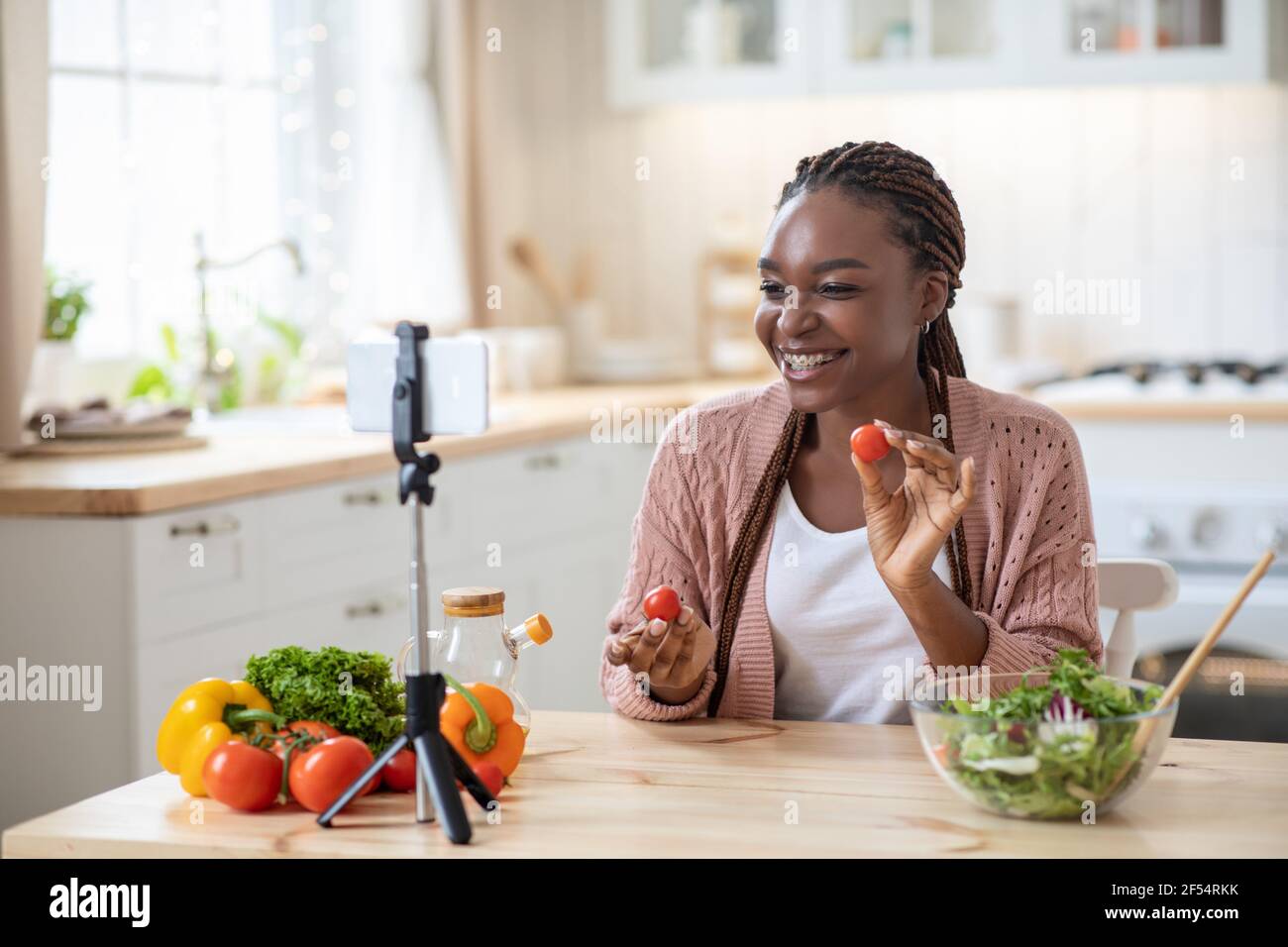 Lebensmittelblogger. Lächelnd junge afrikanische Frau Aufnahme Video in der Küche zu Hause Stockfoto