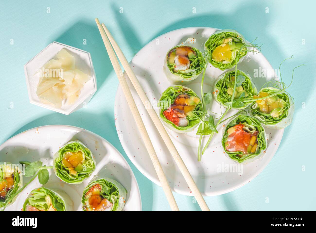 Mediterrane, nordische und Keto Diät-Konzept. Sushi ohne Reis, Diätkost mit Meeresfrüchten, Gemüse. Trendige asiatische Sushi-Stil Frühlingsrollen auf blau Mo Stockfoto