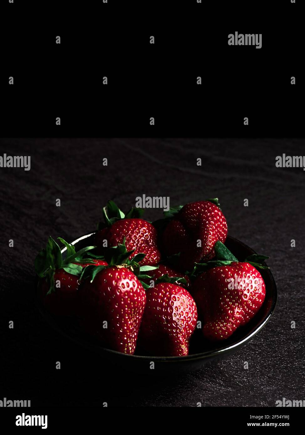 Frische Erdbeeren in einer Schüssel. Dunkles Essen. Stockfoto