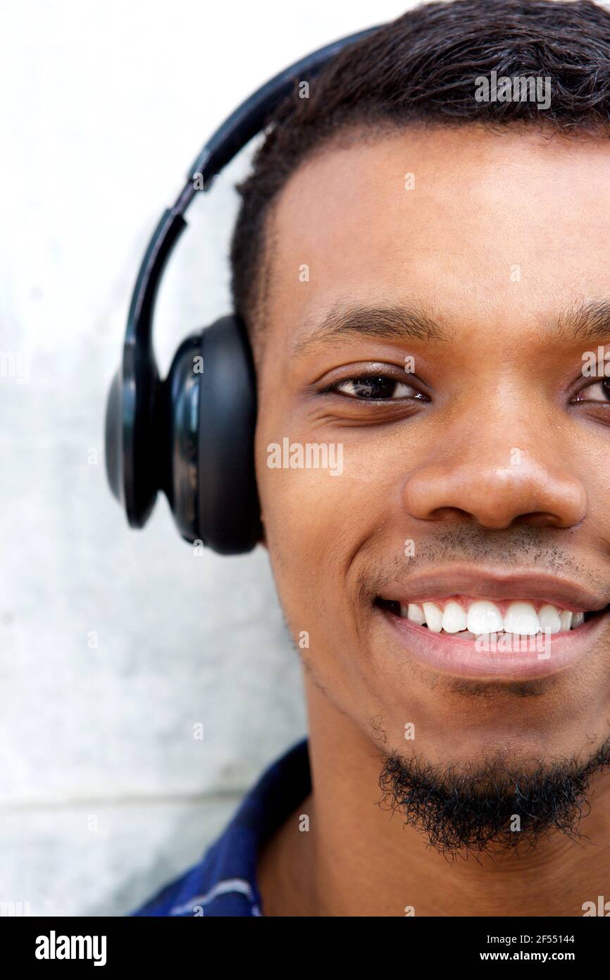 Nahaufnahme Halbportrait eines lächelnden Mannes mit Kopfhörern Zu Musik Stockfoto