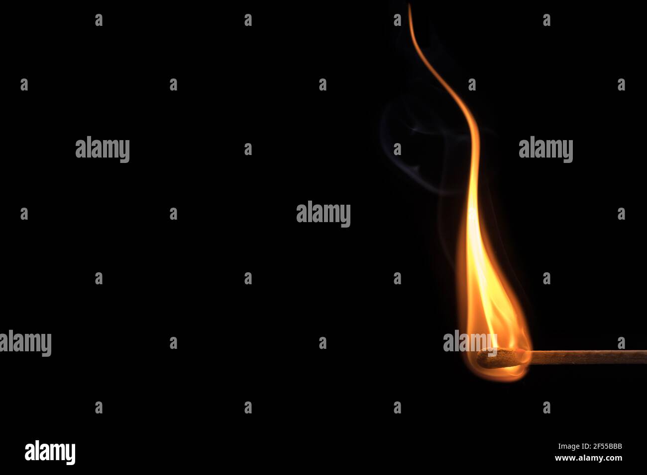 Nahaufnahme einer geschwungenen Flamme eines Streichens Ein schwarzer Hintergrund Stockfoto