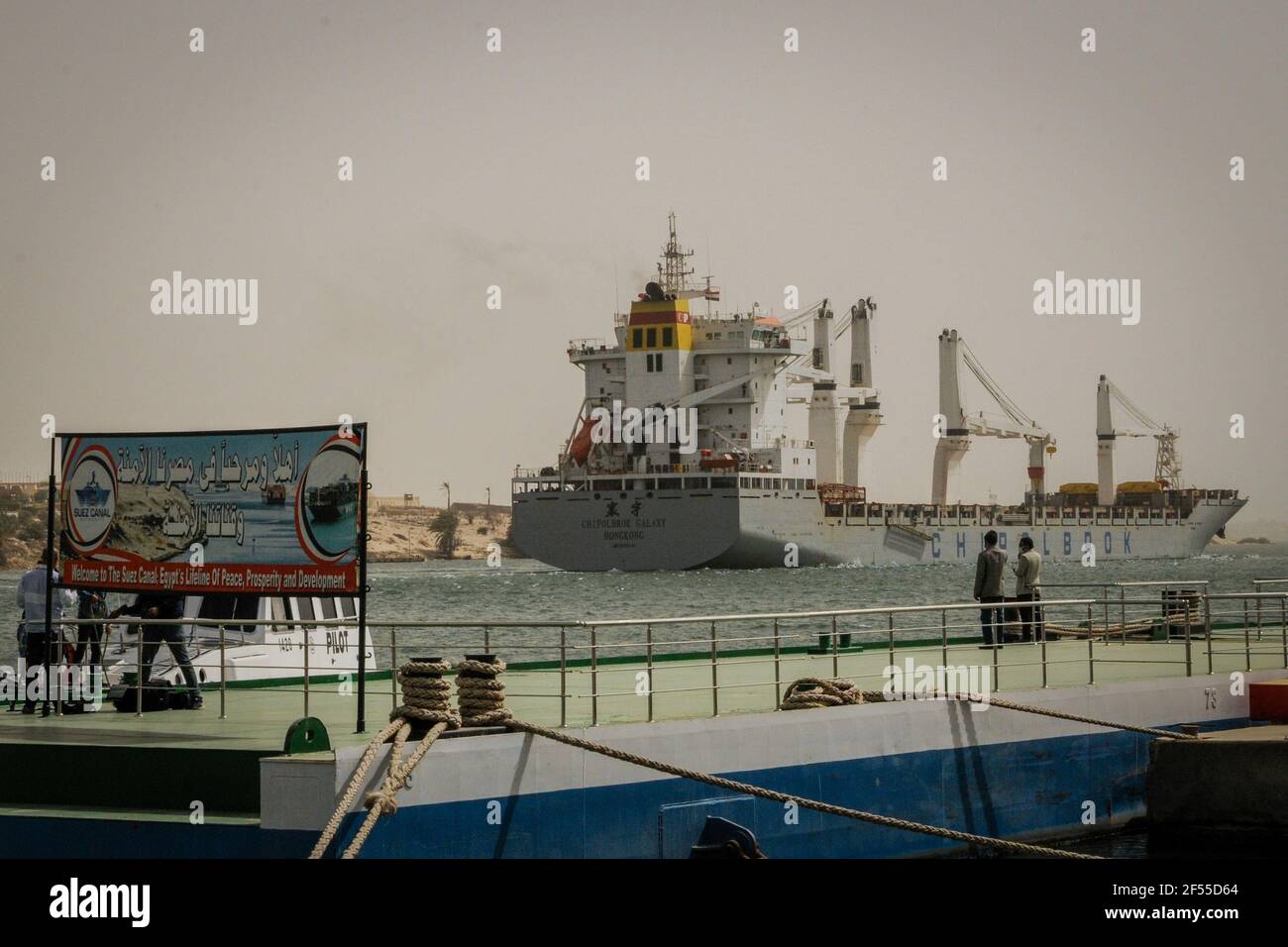 24. März 2021, Ägypten, Suez: Ein Schiff segelt entlang der Wasserstraße des Suezkanals nach der Wiederaufnahme des Navigationsverkehrs nach dem teilweisen Wiederverschwimmen des "ever Given", einem Containerschiff der Evergreen Marine Corporation. Die staatliche Suez Canal Authority (SCA) berichtete, dass acht Schlepper versuchen, den panamaischen Supertanker zu verlagern, nachdem er am südlichen Ende des Suezkanals auf Grund gelaufen war und den Verkehr in beide Richtungen blockierte. Das Schiff drehte sich seitwärts im Kanal, während auf dem Weg von China nach Rotterdam, aufgrund der eingeschränkten Sicht, die durch einen Staubsturm h Stockfoto