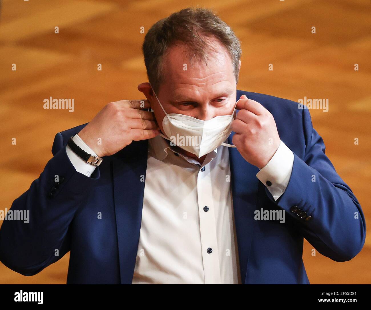 Hamburg, Deutschland. März 2021, 24th. Jens Kerstan (Bündnis90/die Grünen), Senator für Umwelt und Energie in Hamburg, legt nach seiner Rede in der aktuellen Stunde bei einer Sitzung des Hamburger Parlaments im Großen Festspielsaal im Rathaus seinen Mundnasenschutz an. Quelle: Christian Charisius/dpa/Alamy Live News Stockfoto