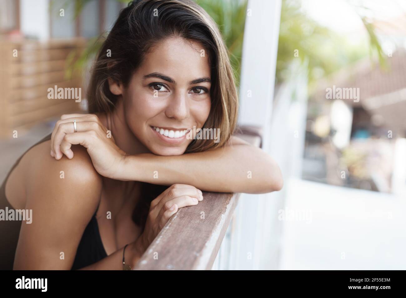 Close-up schön gebräunt Freundin durchbohrt Nase gebräunte Haut schlanke Handlauf Café Terrasse drehen Kamera glücklich lächelnd dankbar Traum wahr werden Mädchen Stockfoto