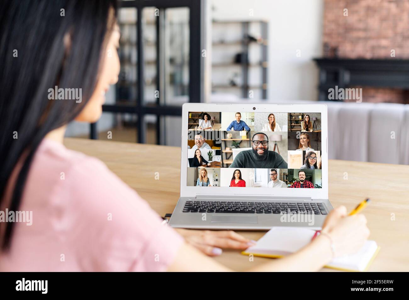Rückansicht über der Schulter einer Frau auf einem Laptop-Bildschirm mit einem vielfältigen Team, Videokonferenz mit Mitarbeitern, Brainstorming, Online-Video-Meeting mit Kollegen Stockfoto