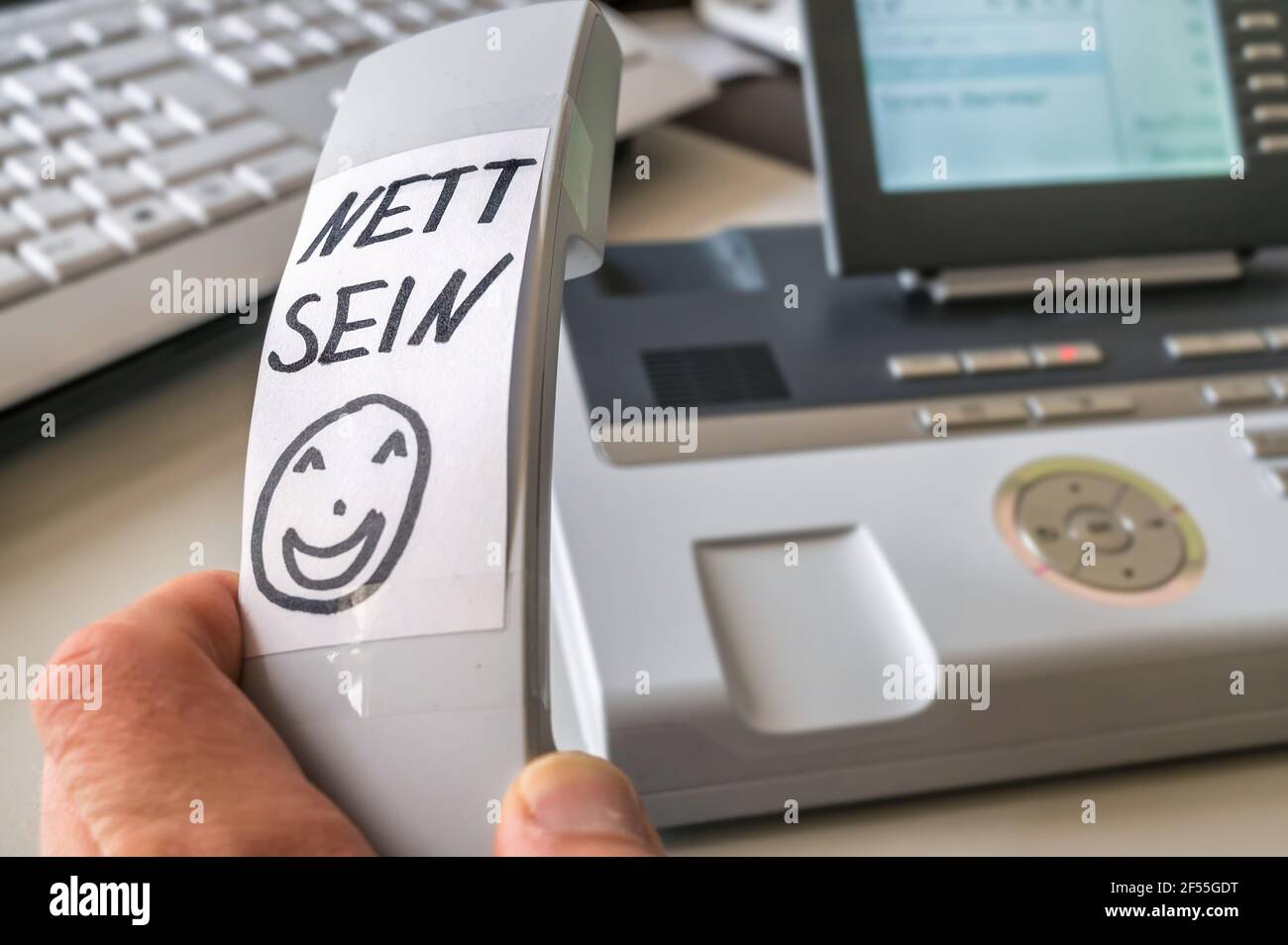 Notieren Sie sich auf dem Empfänger von „Nice to be“ auf Deutsch Ein Telefon als Erinnerung an die freundliche Behandlung von Der Anrufer Stockfoto