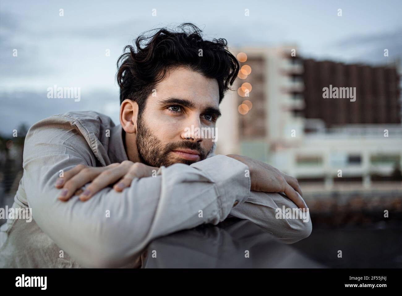 Geschäftsmann mit gekreuzten Armen, gelehnt an Geländer Stockfoto