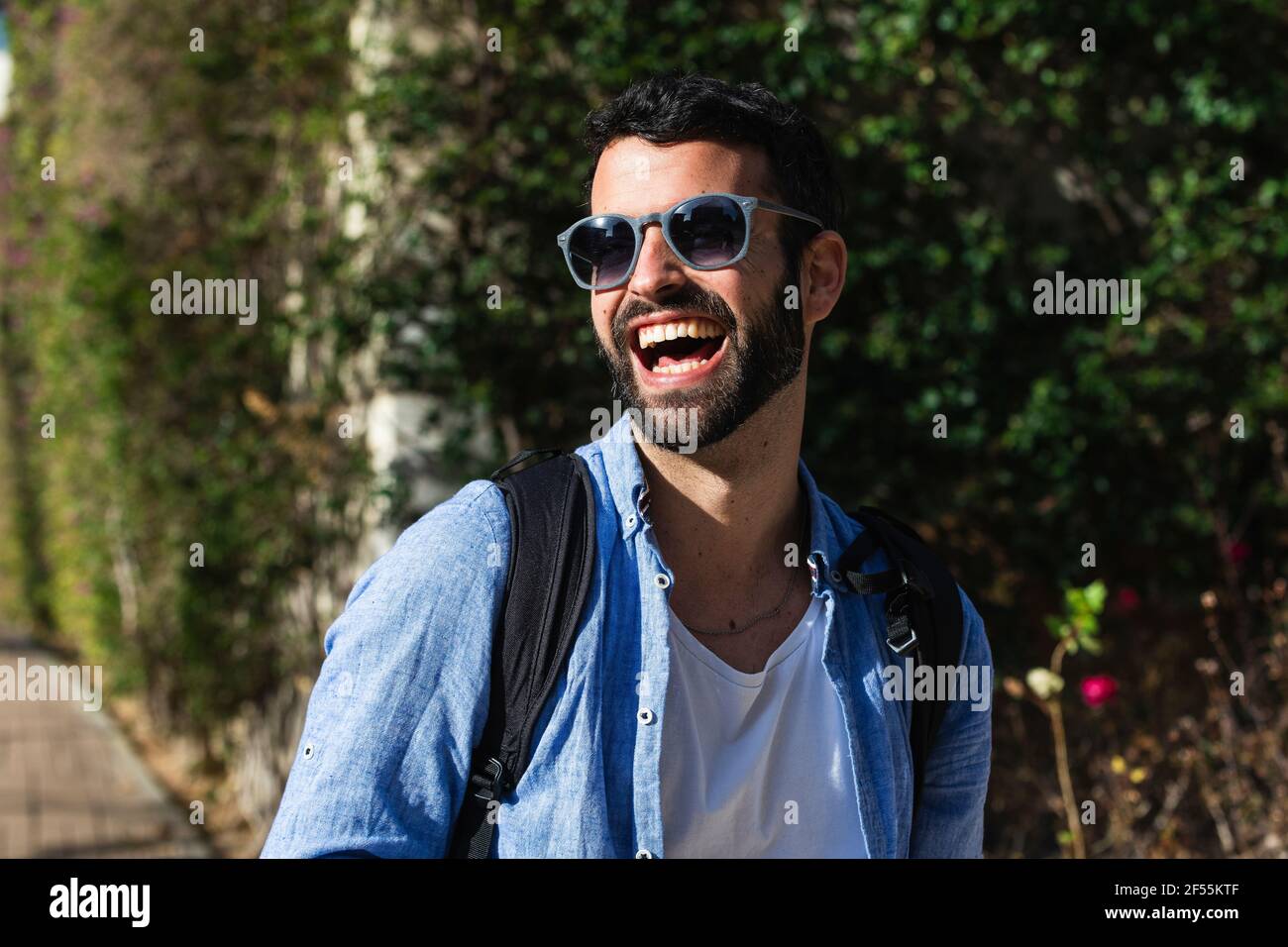 Fröhlicher männlicher Geschäftsmann mit Sonnenbrille im Park Stockfoto