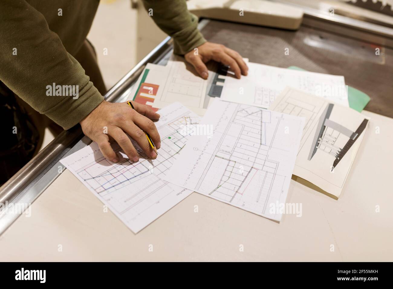 Männlicher Designprofi, der mit handwerklichem Design auf Papier arbeitet und an der Werkbank in der Industrie steht Stockfoto
