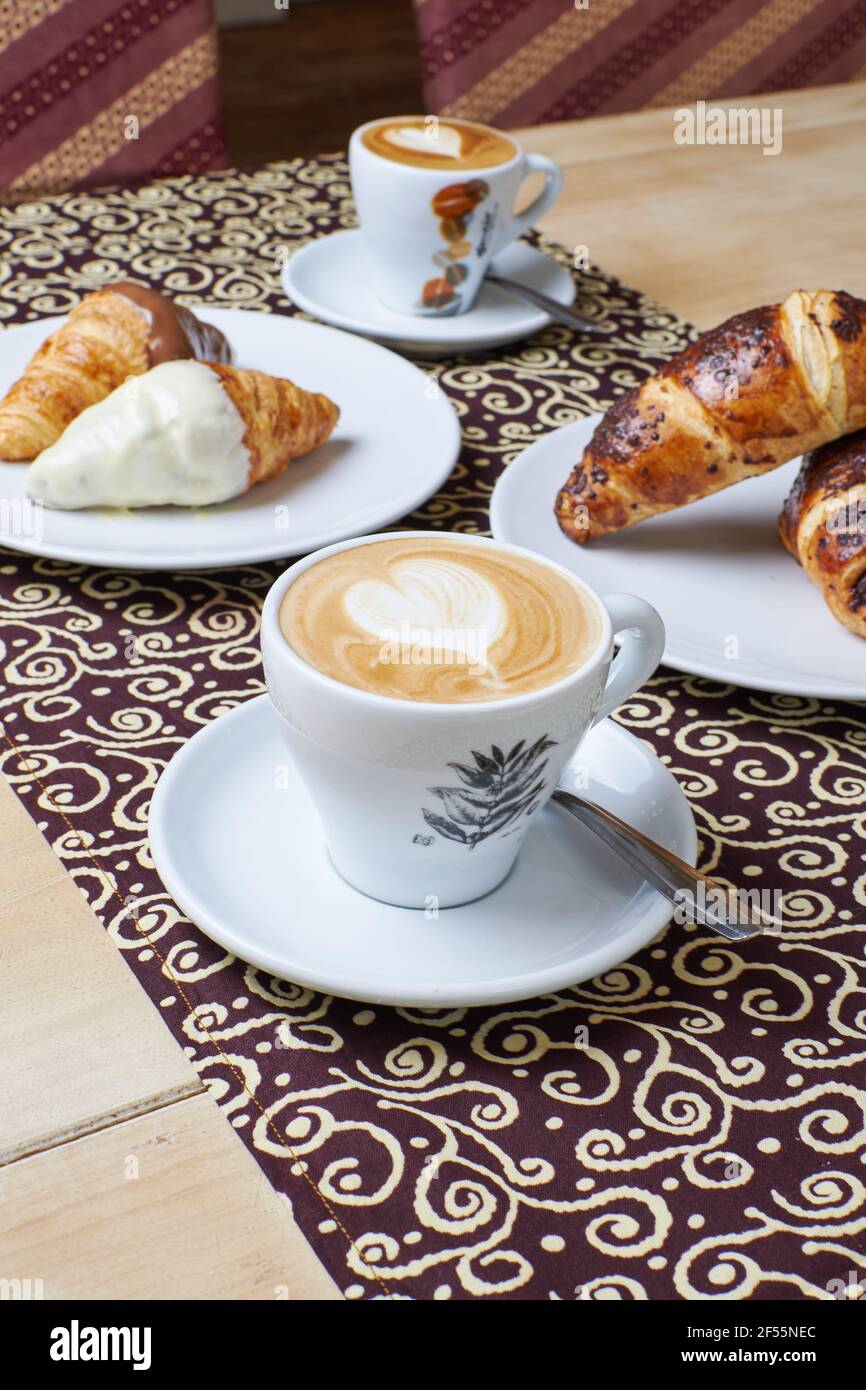 Kaffee-Frühstück mit drei Arten von Croissants in einem Tisch Hintergrund Stockfoto