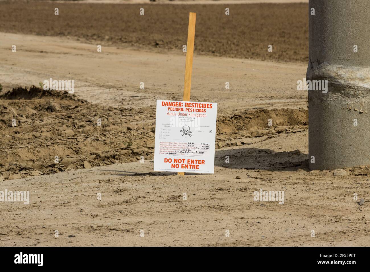 Ein Warnzeichen, das vor der Anwendung von Pestizid-Begasungsmitteln auf einen alten Mandelgarten im Central Valley in den USA warnt. Stockfoto