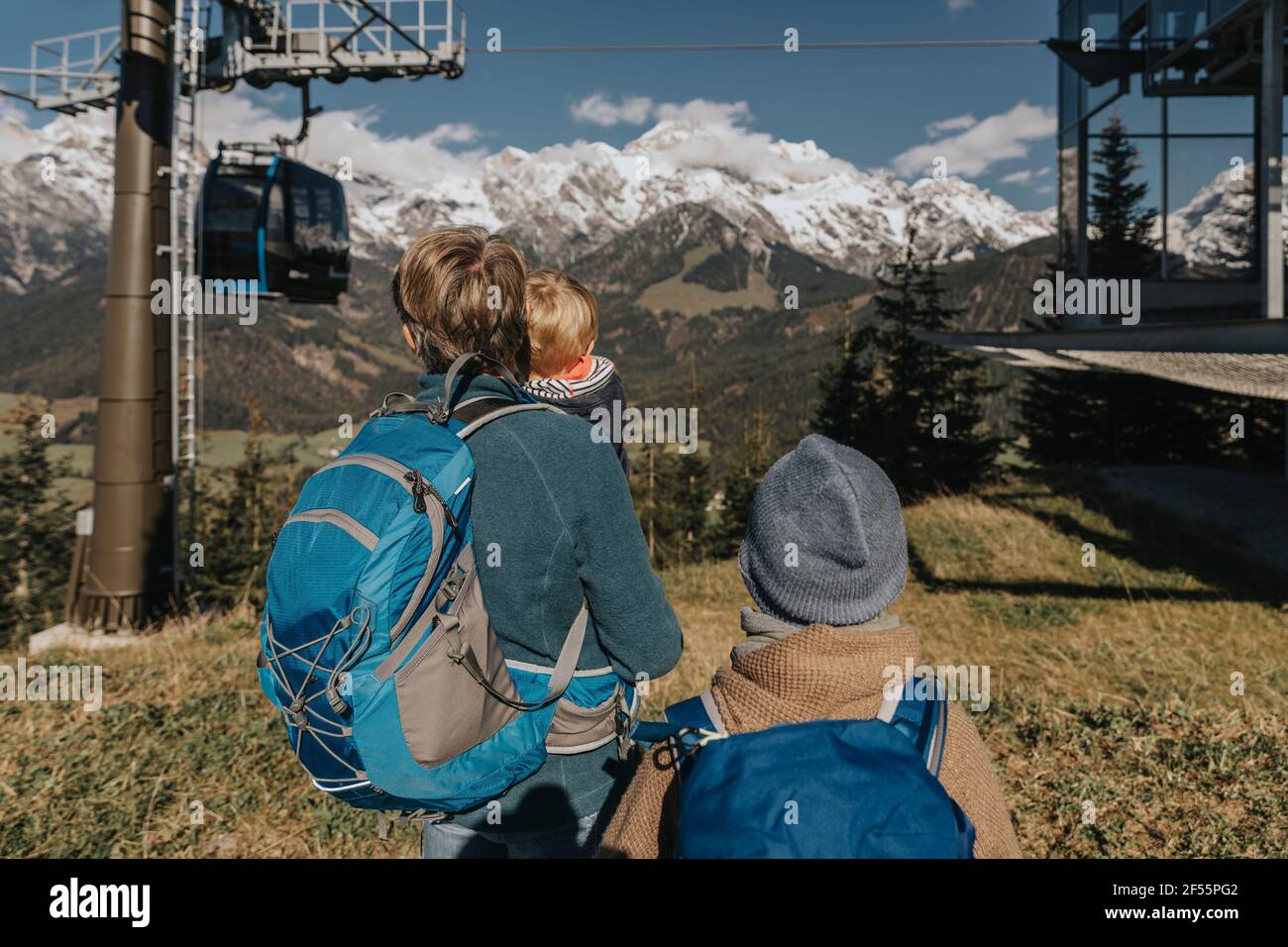 Mann mit zwei Kindern, die die Seilbahn betrachten, während sie auf dem Hochkonig im Salzburger Land stehen Stockfoto