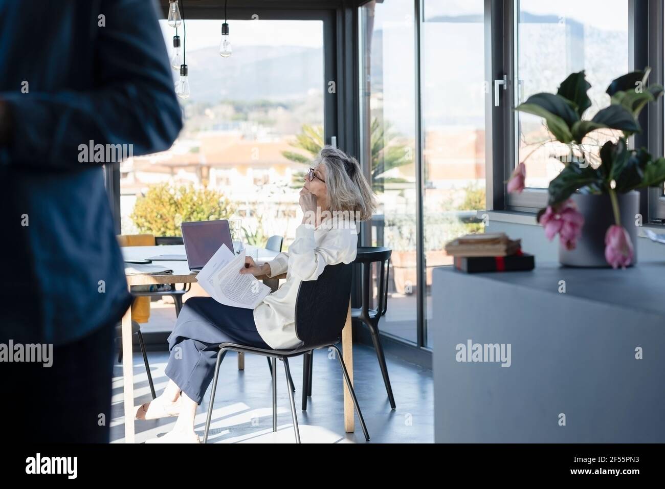 Mann, der mit einer nachdenklichen Frau im Hintergrund zu Hause steht Stockfoto