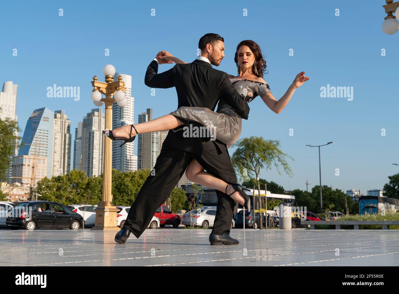 Selbstbewusste Tänzerinnen und Tänzer üben auf Fußwegen gegen Blau Himmel Stockfoto