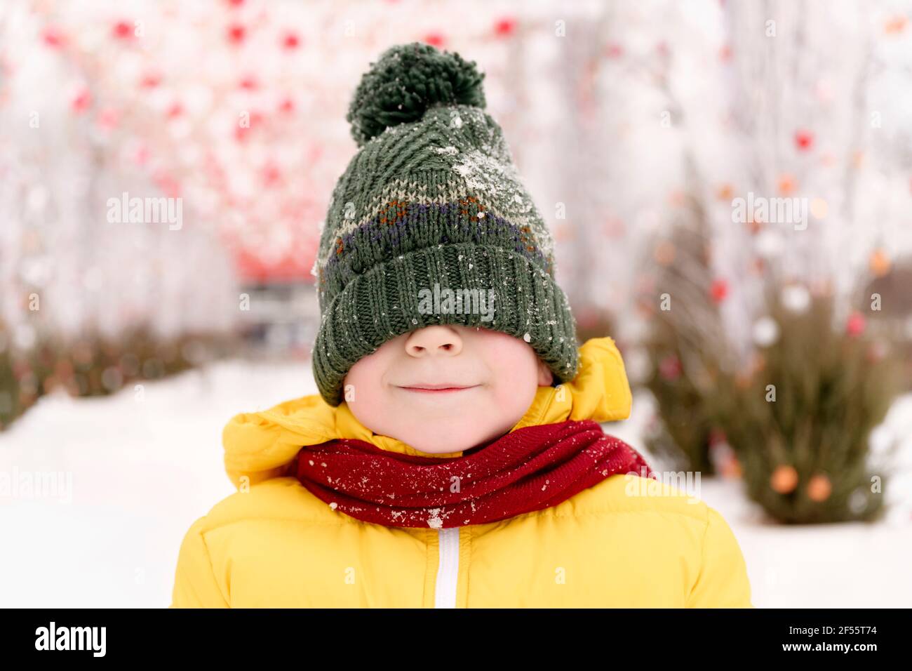 Junge versteckt sein Gesicht mit Strickmütze Stockfoto