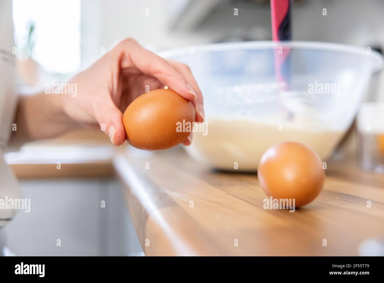 Frau bricht Eier in der Küche Stockfoto