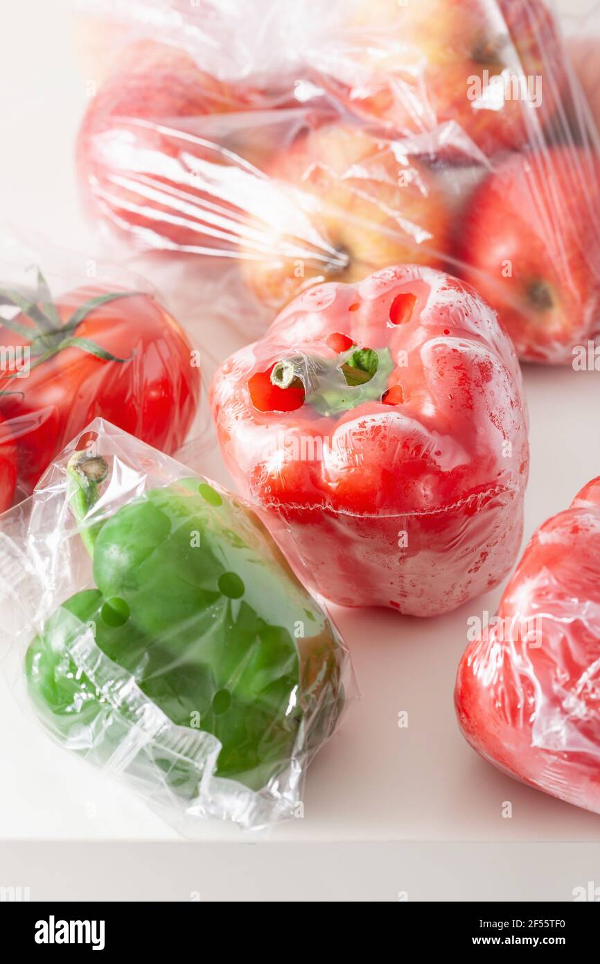 Single use Kunststoffverpackungen. Peperoni Tomaten äpfel Gemüse in Plastiktüten Stockfoto