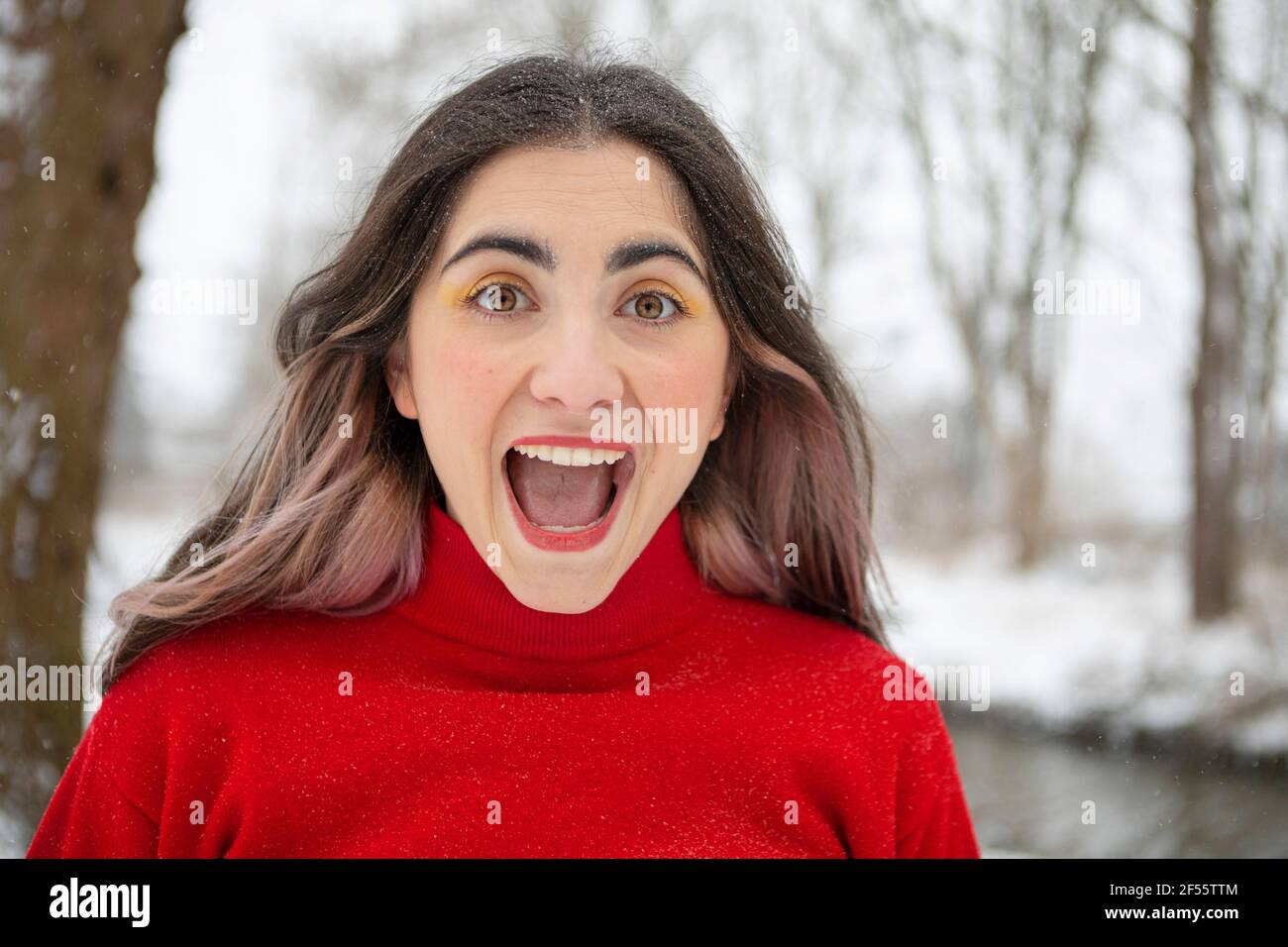 Verspielte Frau mit offenem Mund im Winter Stockfoto