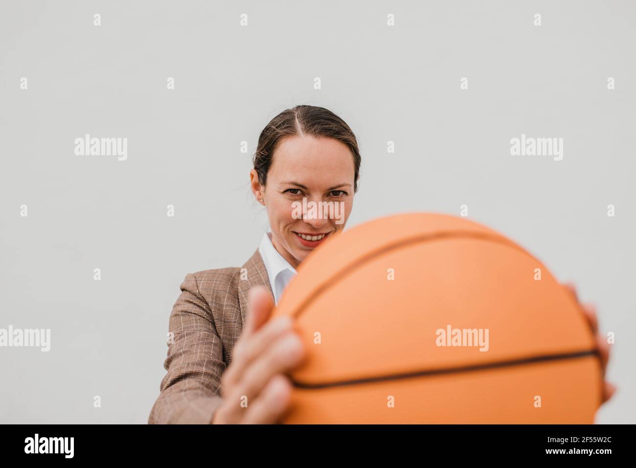 Lächelnde Profikerin mit Basketball in der Pause Stockfoto Lächelnde Profikerin mit Basketball in der Pause Stockfoto