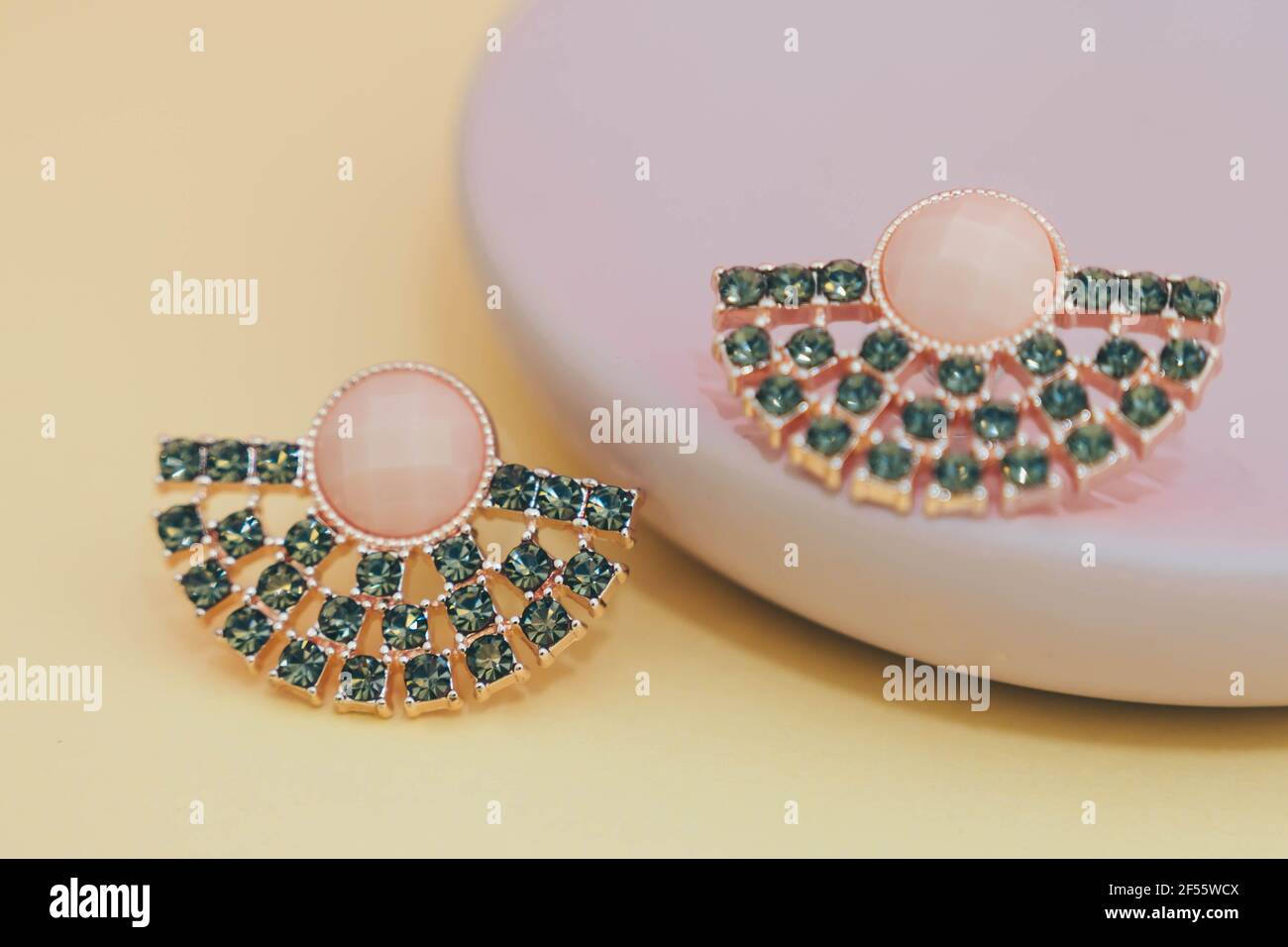 Nahaufnahme von Diamantohrringen isoliert auf pastellgelb und Rosa Hintergrund Stockfoto
