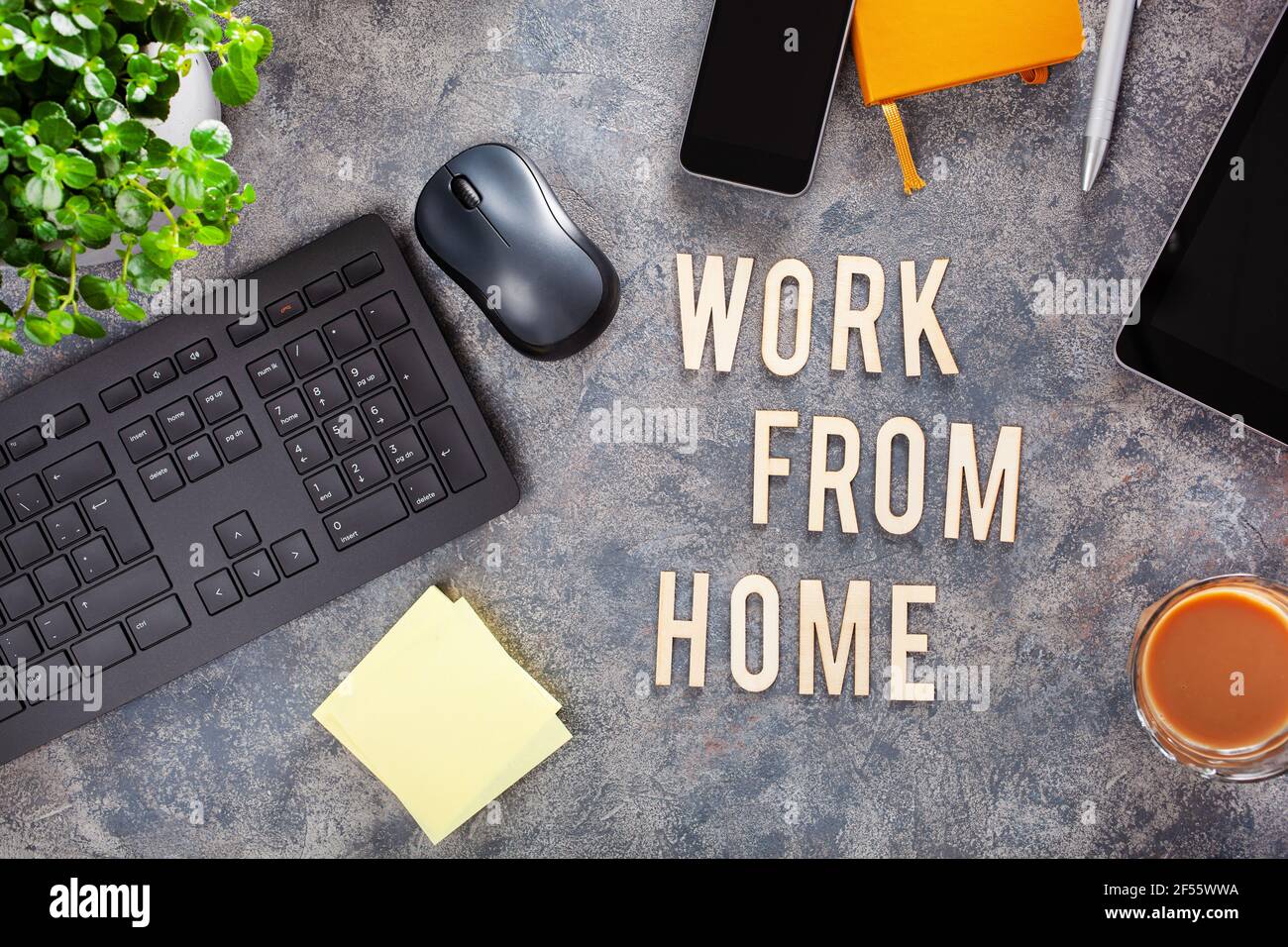 Arbeiten Sie von zu Hause aus mit einem Text-Desk mit Tastatur Computer Smartphone Notebook Houseplants, Arbeitsplatz Büro zu Hause Stockfoto