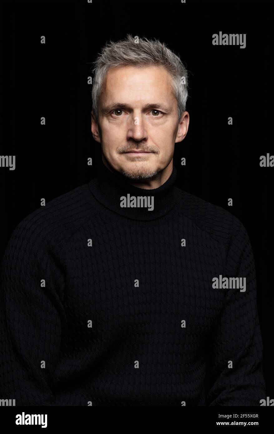 Ernst reifen Mann vor schwarzem Hintergrund Stockfoto
