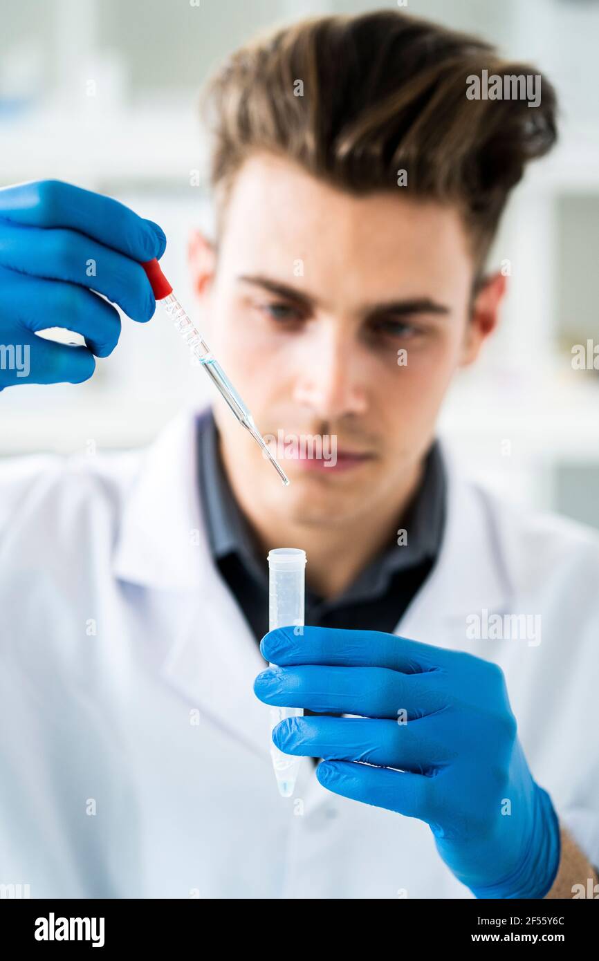 Wissenschaftler mit Reagenzglas und Pipette bei der Herstellung von Chemikalien Im Labor Stockfoto