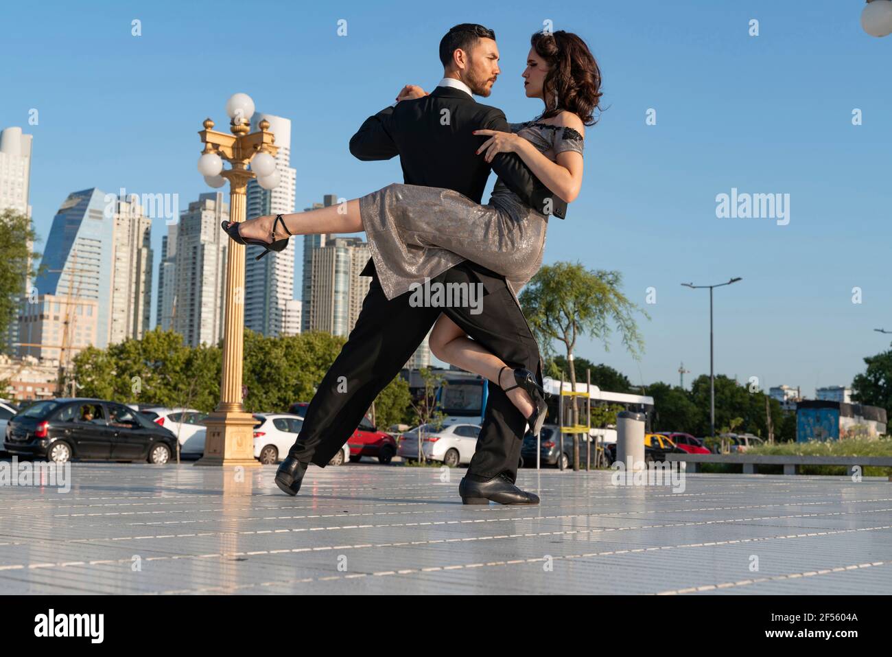 Männliche und weibliche Tänzerinnen schauen sich beim Üben an Tango-Tanz auf dem Fußweg Stockfoto