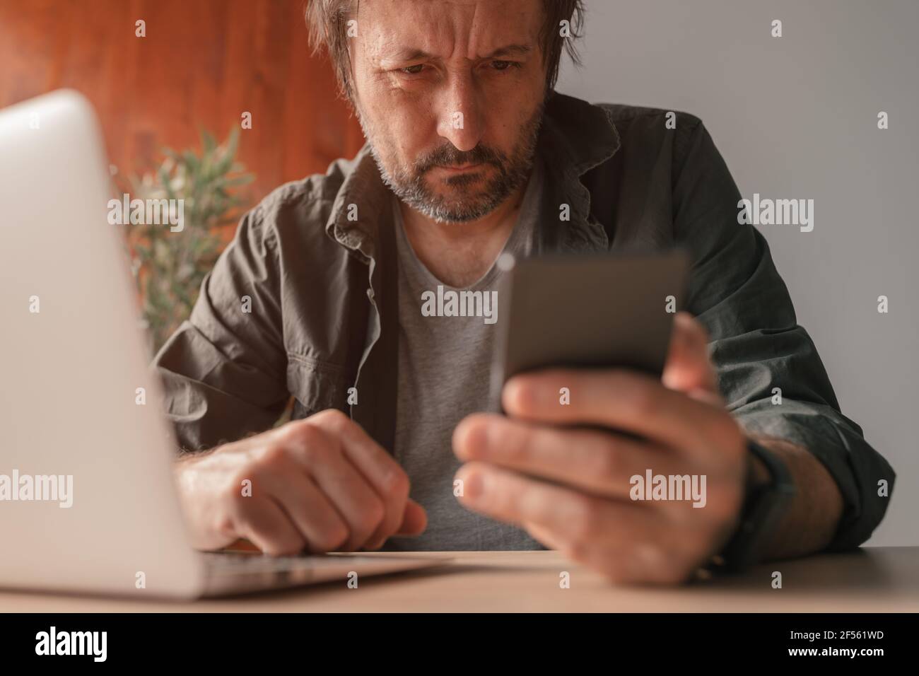 Freiberuflicher Mitarbeiter, der im Heimbüro ein mobiles Smartphone verwendet, Nahaufnahme mit selektivem Fokus Stockfoto