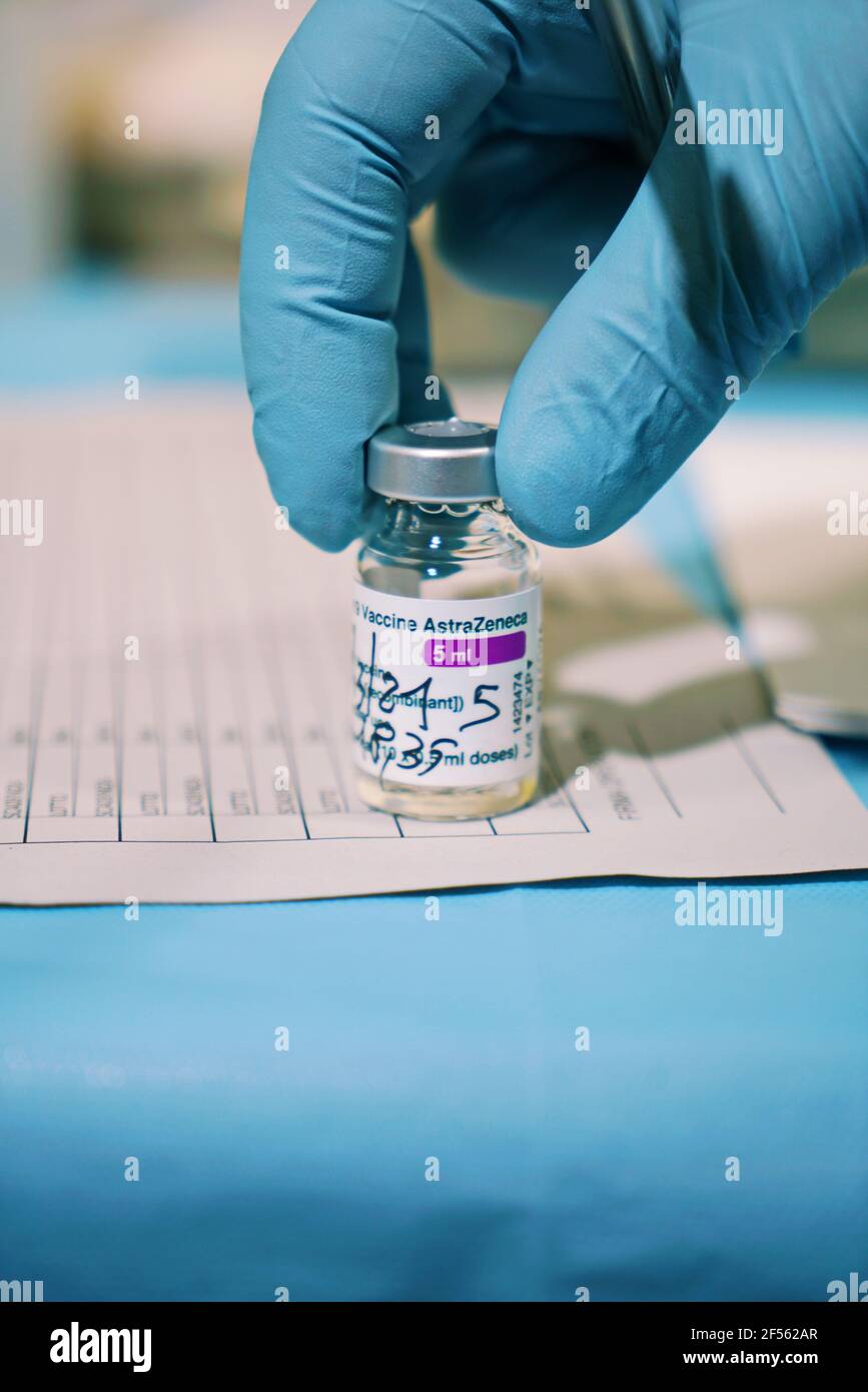 Fläschchen mit COVID-19-Impfstoff, hergestellt von AstraZeneca. Die Hand des Arztes in einem medizinischen Handschuh hält eine Flasche mit einem Coronavirus-Impfstoff. Selektiver Fokus. Turin, Stockfoto