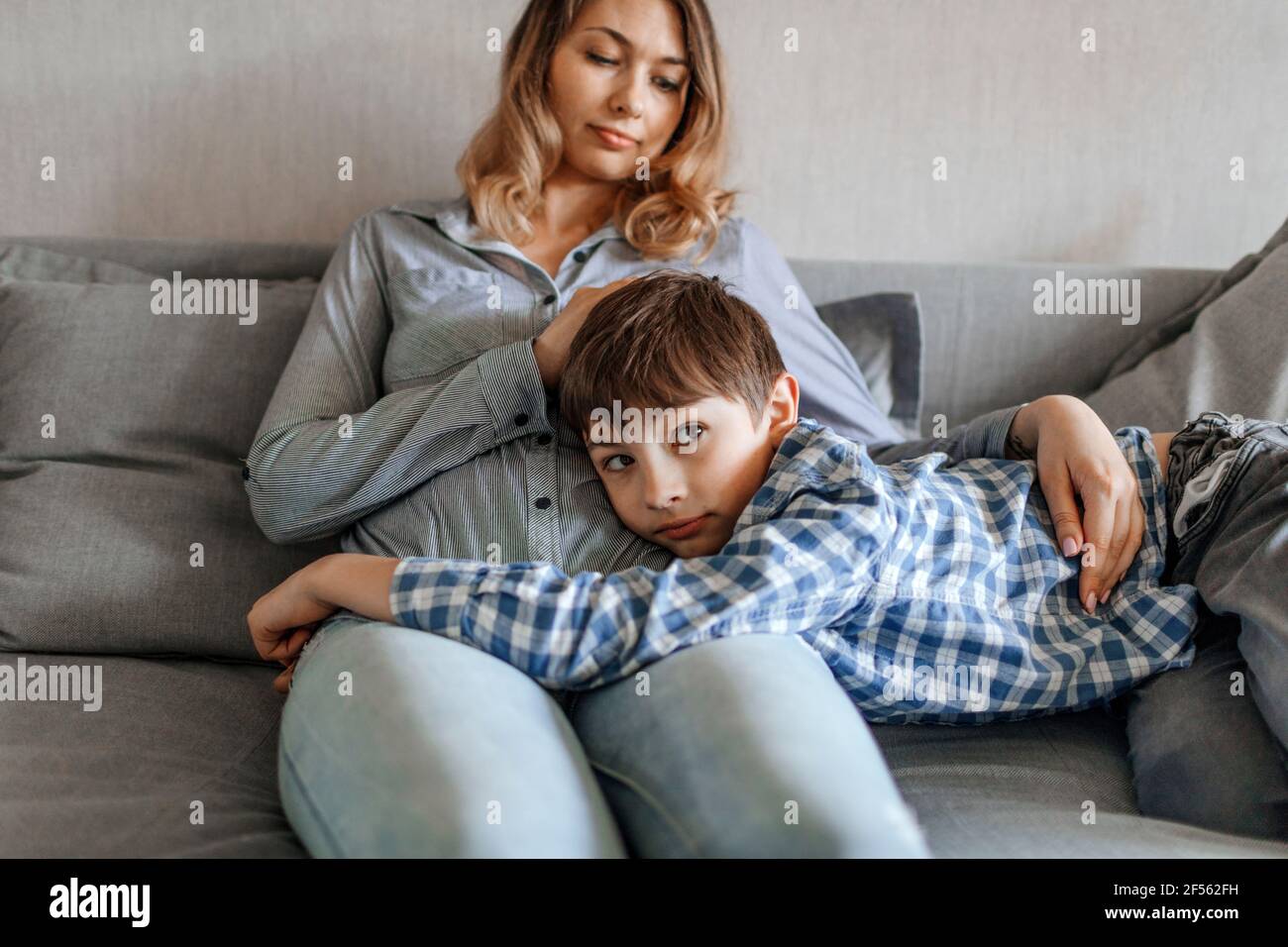 Mutter bewundert den Sohn zu Hause auf dem Sofa Stockfoto