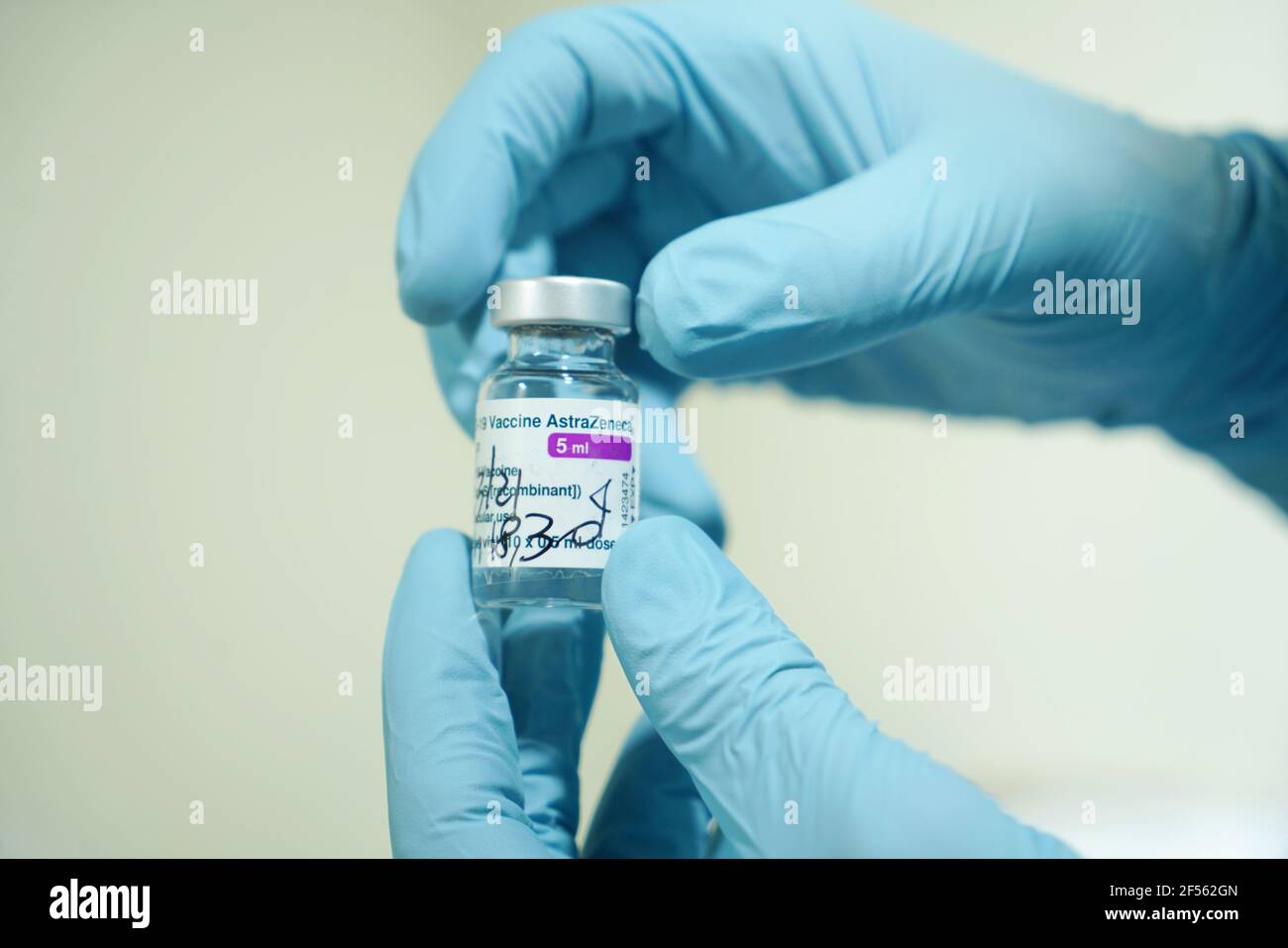Fläschchen mit COVID-19-Impfstoff, hergestellt von AstraZeneca. Die Hand des Arztes in einem medizinischen Handschuh hält eine Flasche mit einem Coronavirus-Impfstoff. Selektiver Fokus. Turin, Stockfoto
