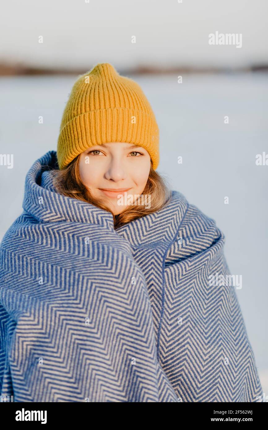 Portrait von schönen Teenager-Mädchen tragen Strickmütze Erwärmung sich Oben mit Wolldecke Stockfoto