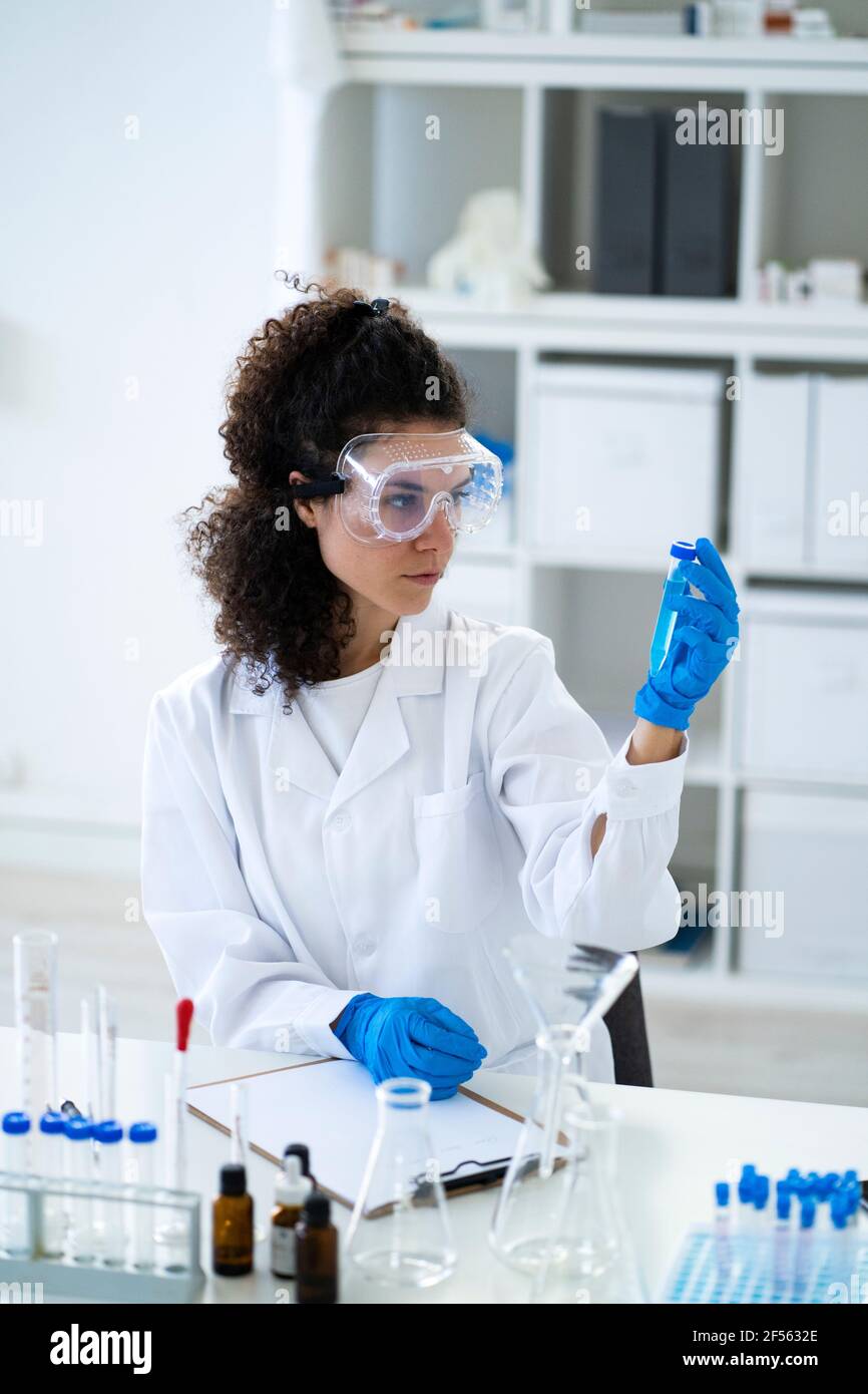 Wissenschaftlerin, die chemische Lösung im Reagenzglas im Labor analysiert Stockfoto