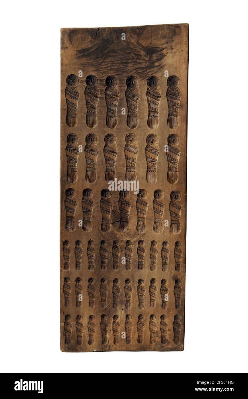 Volkskunst Holzmodell mit Wickel Kinder. Diese Holzmodelle aus dem 18th. Jahrhundert dienten der Herstellung von Bäckereien in Form von Wickelkindern. Nach Volksbräuchen aßen sie sie am Silvesterabend oder am Neujahrsmorgen, um sich zu versichern, dass sie für das kommende Jahr Fruchtbarkeit hofften. Das Gebäck wurde vor allem bei Hochzeiten zubereitet. Die essbare Kinderwäsche wurde auf dem Brautkuchen dekoriert oder direkt in den Hochzeitstorte eingearbeitet. Mit diesem Geschenk war die Braut ein tolles Kindersortiment wie möglich. Stockfoto