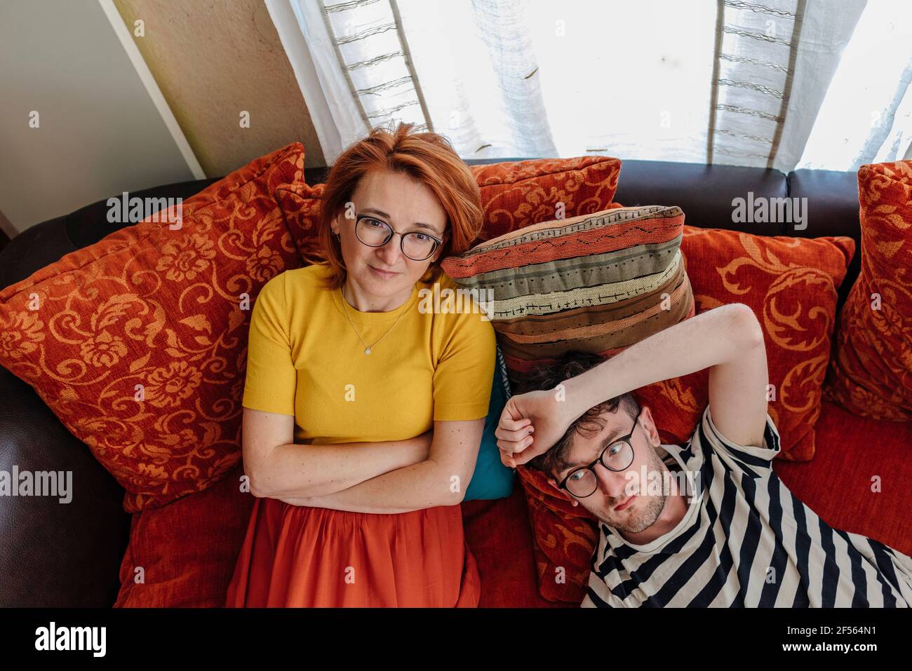 Nachdenkliche Mutter und Sohn entspannen sich zu Hause auf dem Sofa Stockfoto