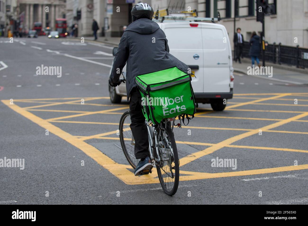 London, Großbritannien. 24. März 2021. Ein Uber Eats Fahrer fährt durch die City of London. Wettbewerber Deliveroo bereitet sich auf eine Börsennotierung £8,8bn am 7. April vor, aber einige Kommentatoren haben auf das Investitionsrisiko hingewiesen, dass Lieferfahrer nicht als Angestellte eingestuft werden und somit nicht die Rechte auf Mindestlohn, Urlaub oder Krankenstand haben. Die meisten Fahrer des Unternehmens wird mit Boni bis zu £10.000 nach dem Börsengang vergeben werden. Kredit: Stephen Chung / Alamy Live Nachrichten Stockfoto