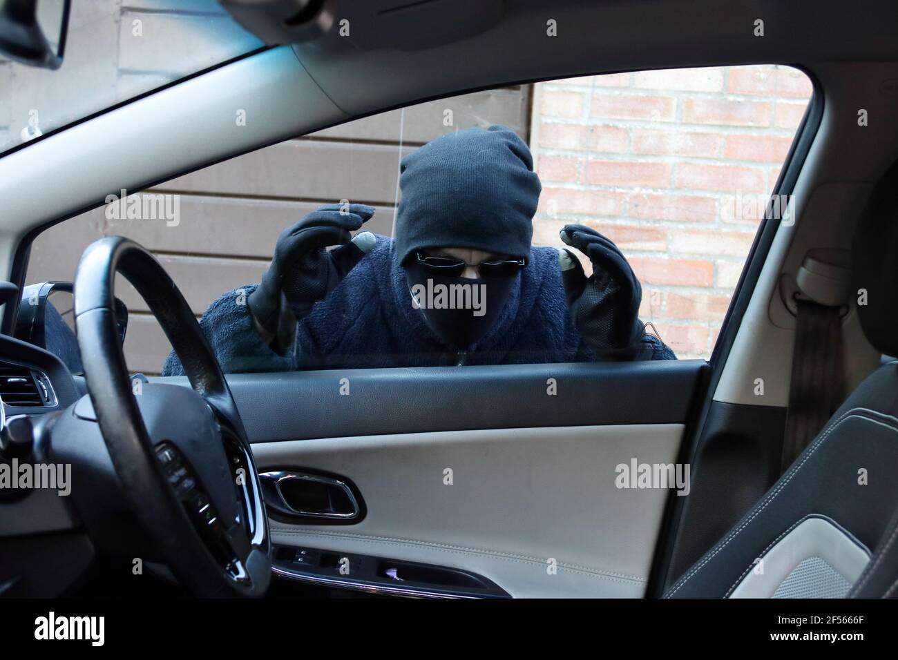 Dieb auf der Suche durch Autofenster Stockfoto