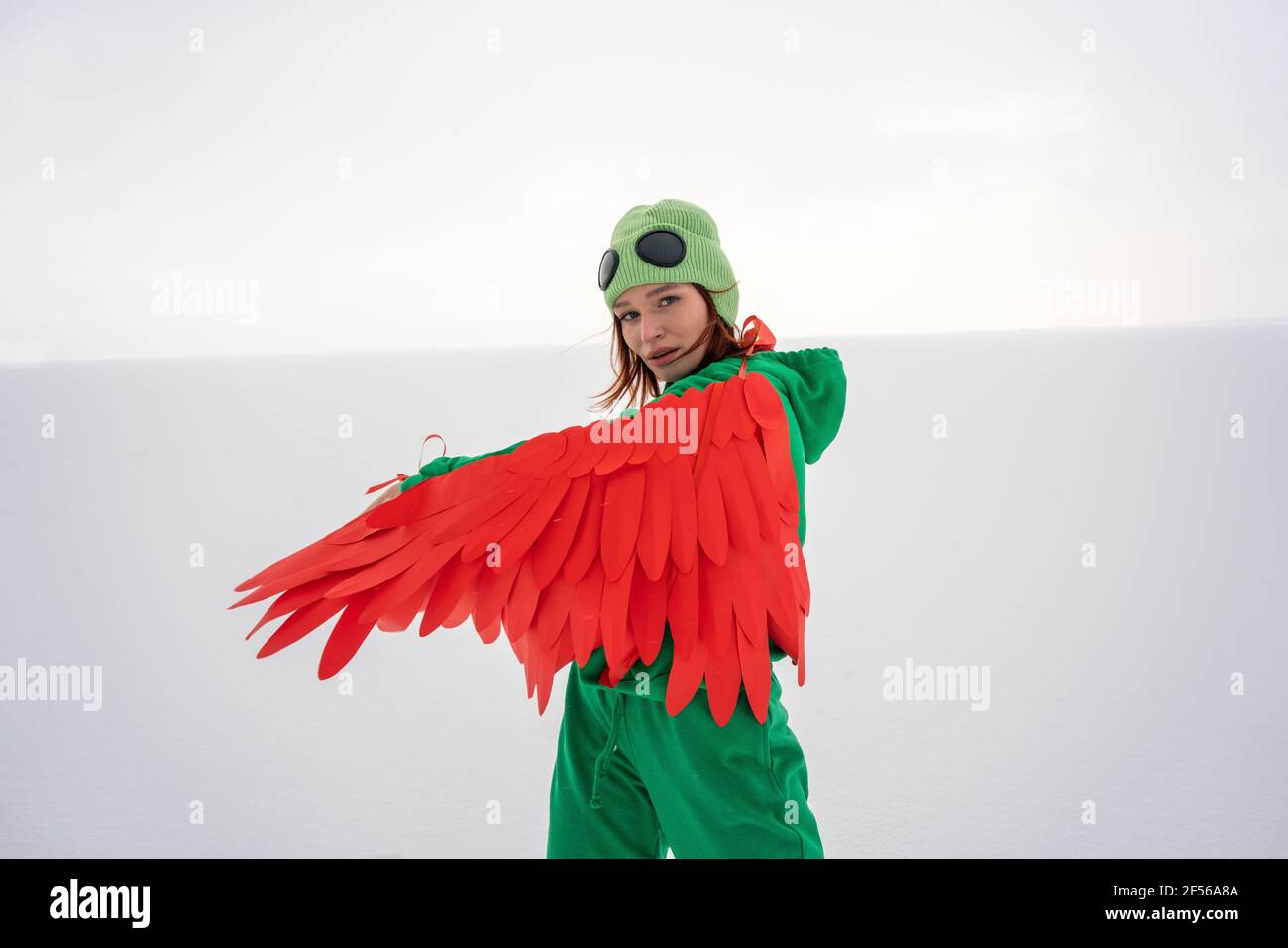 Frau mit roten Flügeln auf Schnee am Himmel Stockfoto