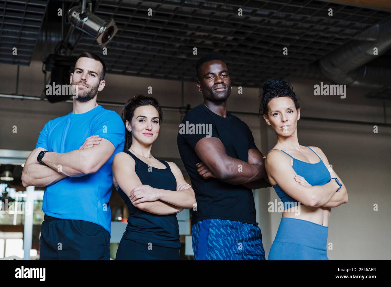 Multiethnische Gruppe von Sportlern mit gekreuzten Armen Fitnessraum Stockfoto