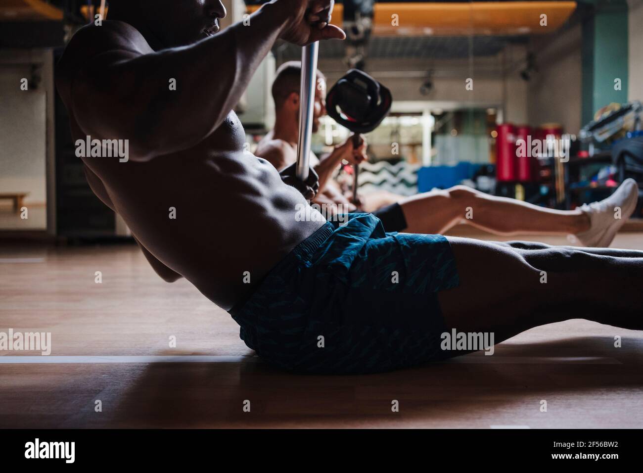 Sport Menschen tun Krafttraining, während das Training mit Langhantel in Fitnessraum Stockfoto