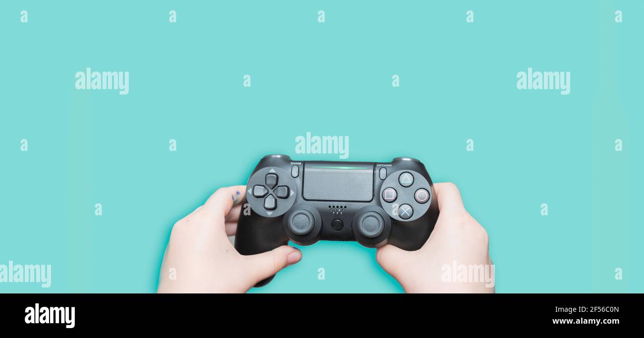 Mädchen Hand halten Spiel-Controller auf pastellblauem Hintergrund isoliert. Videospiel Konsole Controller in Gamer Hände Stockfoto