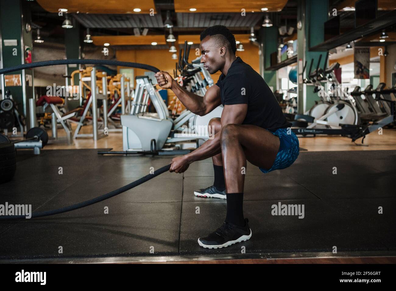 Muskulöser Sportler beim Sporttraining im Fitnessstudio mit Seil trainieren Stockfoto
