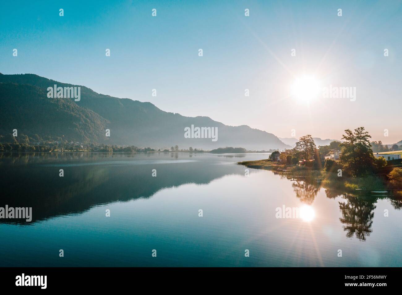 Sonnenaufgang Blick auf den Ossiacher See gegen Berg und klaren Himmel, Österreich Stockfoto