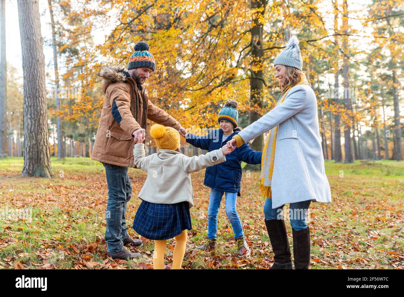 Kinder halten die Hand der Eltern, während sie im Wald spielen Stockfoto