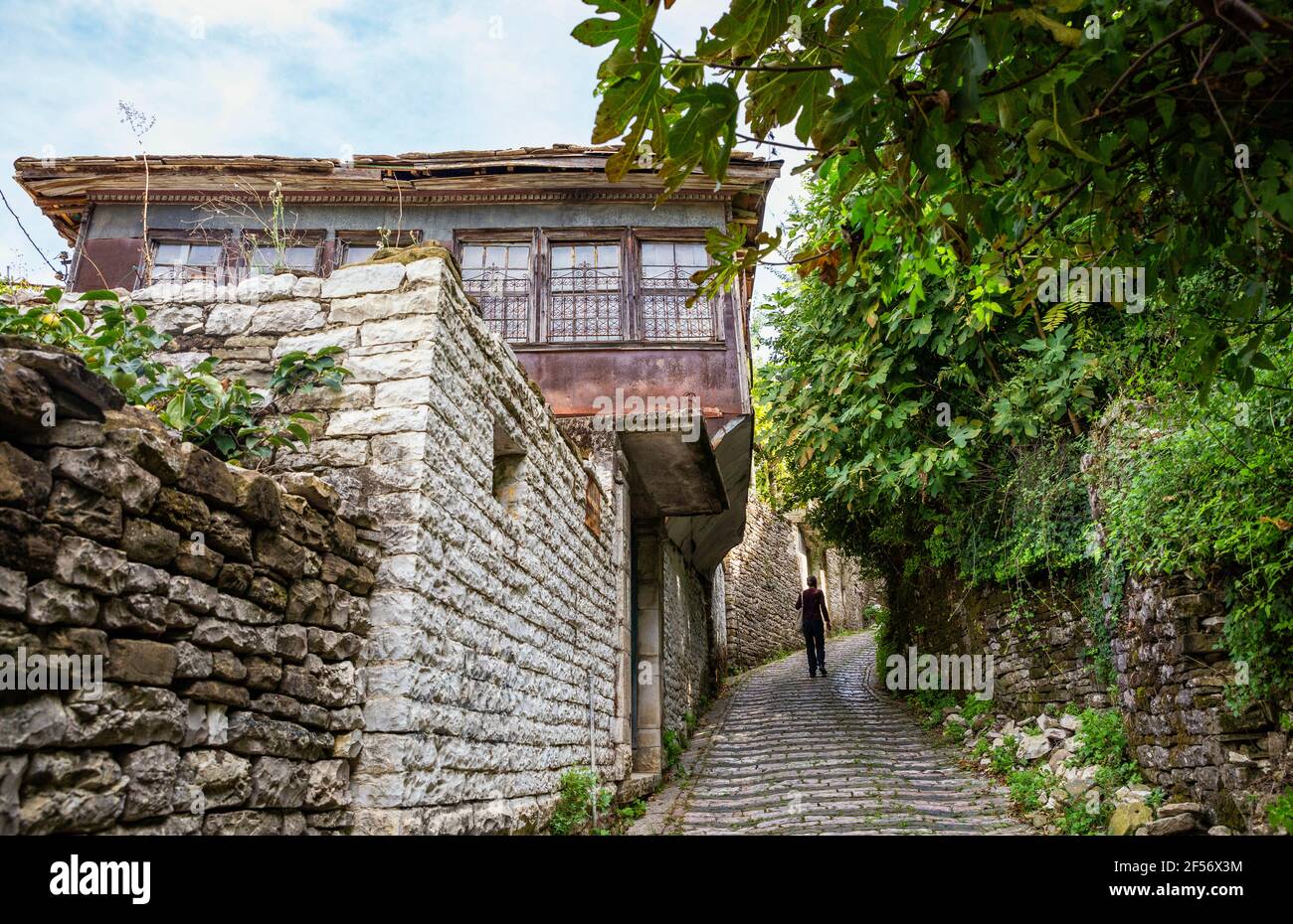 Mann, der auf einem Fußweg durch das Haus in Gjirokaster, Albanien, läuft Stockfoto