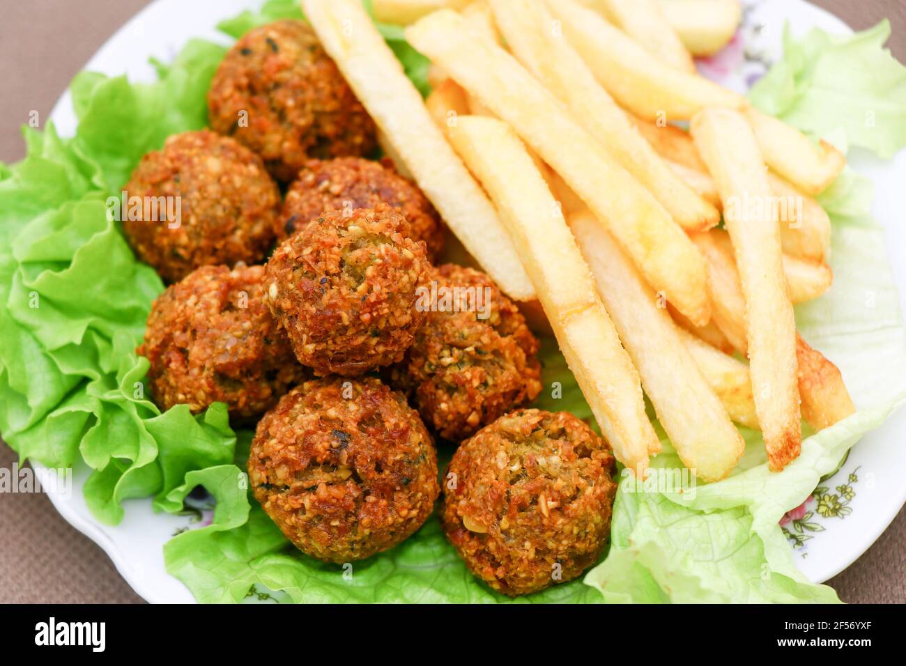 Mediterranes Street Food. Falafel mit Pommes auf dem Salat. Stockfoto