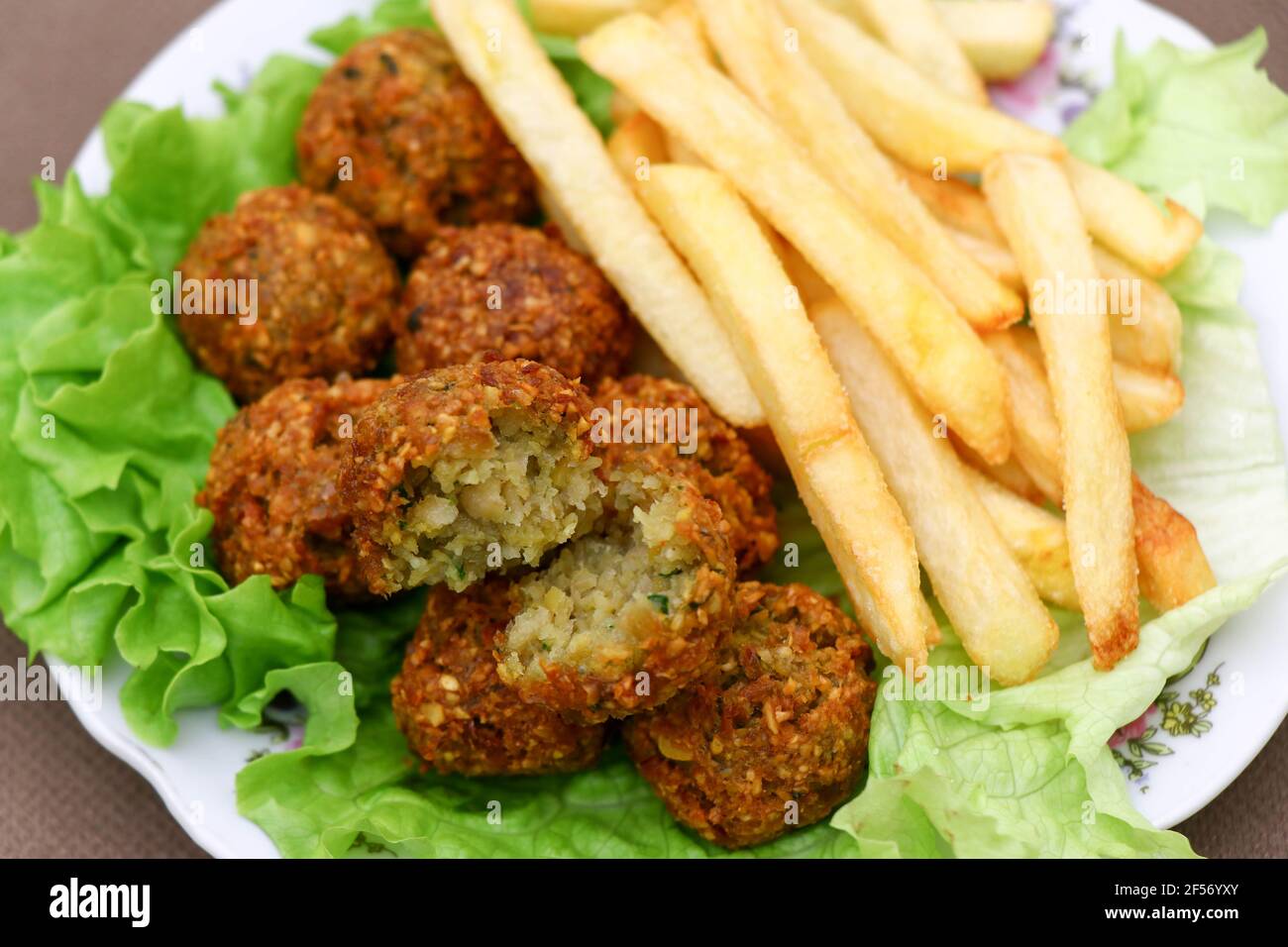 Mediterranes Street Food. Falafel mit Pommes auf dem Salat. Stockfoto